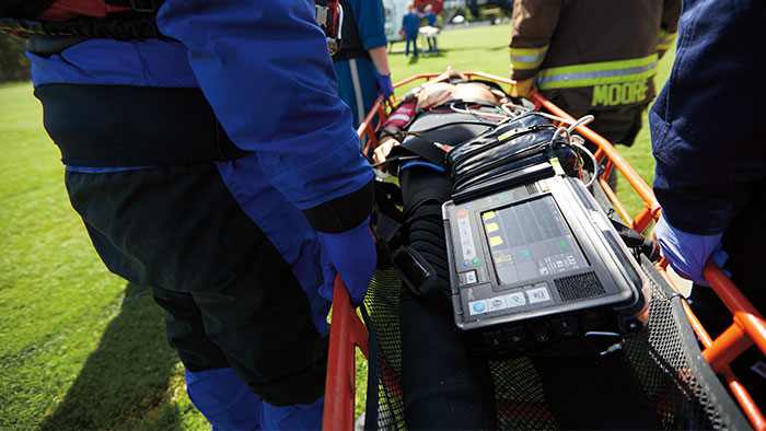 a patient being carried on a stretcher with Tempus beside them