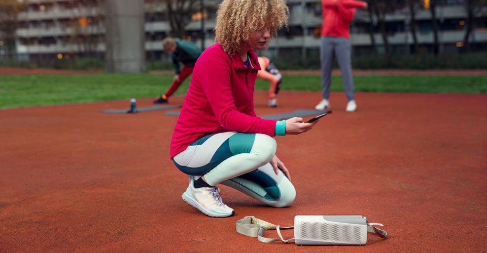 Žena se venku připojuje ke svému Philips Bluetooth reproduktoru