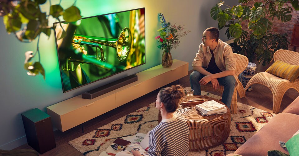 Lidé, kteří si užívají televizor Philips Ambilight s ostrým zvukem soundbaru