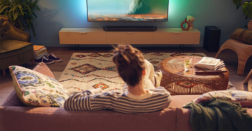 Žena si užívá svůj Philips Soundbar v obývacím pokoji