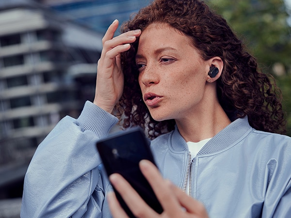 Žena si užívá funkci křišťálového hovoru Philips sluchátek