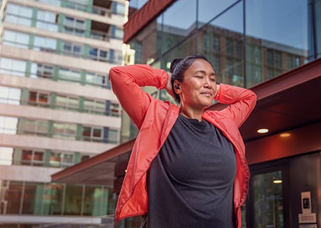 Žena pomocí venkovních bezdrátových sluchátek Philips A5508