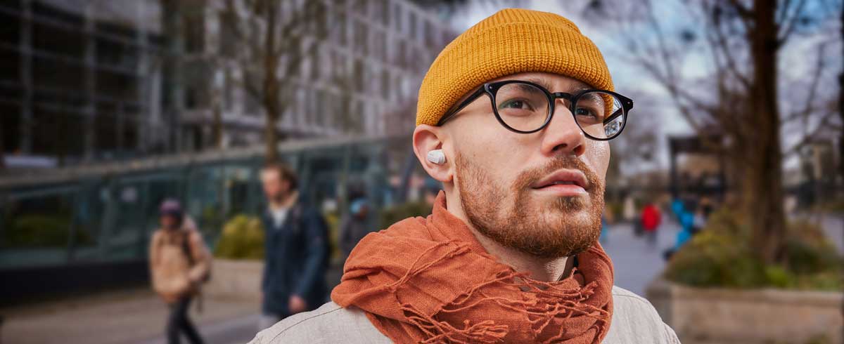 Detailní fotografie muže, který nosí opravdová bezdrátová sluchátka