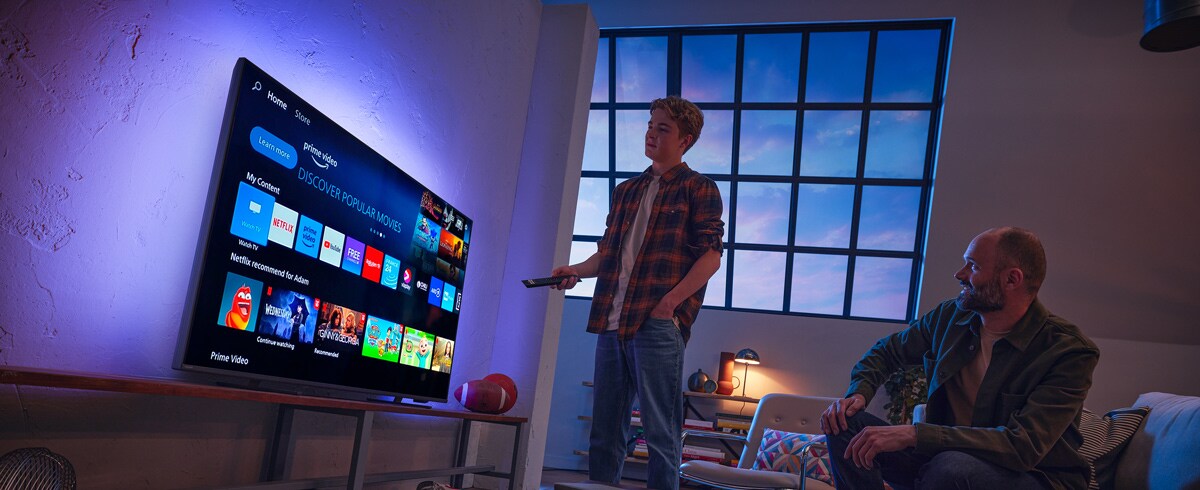 Muž vybírající aplikaci na televizoru Philips Smart TV