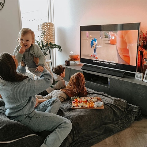 Rodina sleduje televizi Ambilight